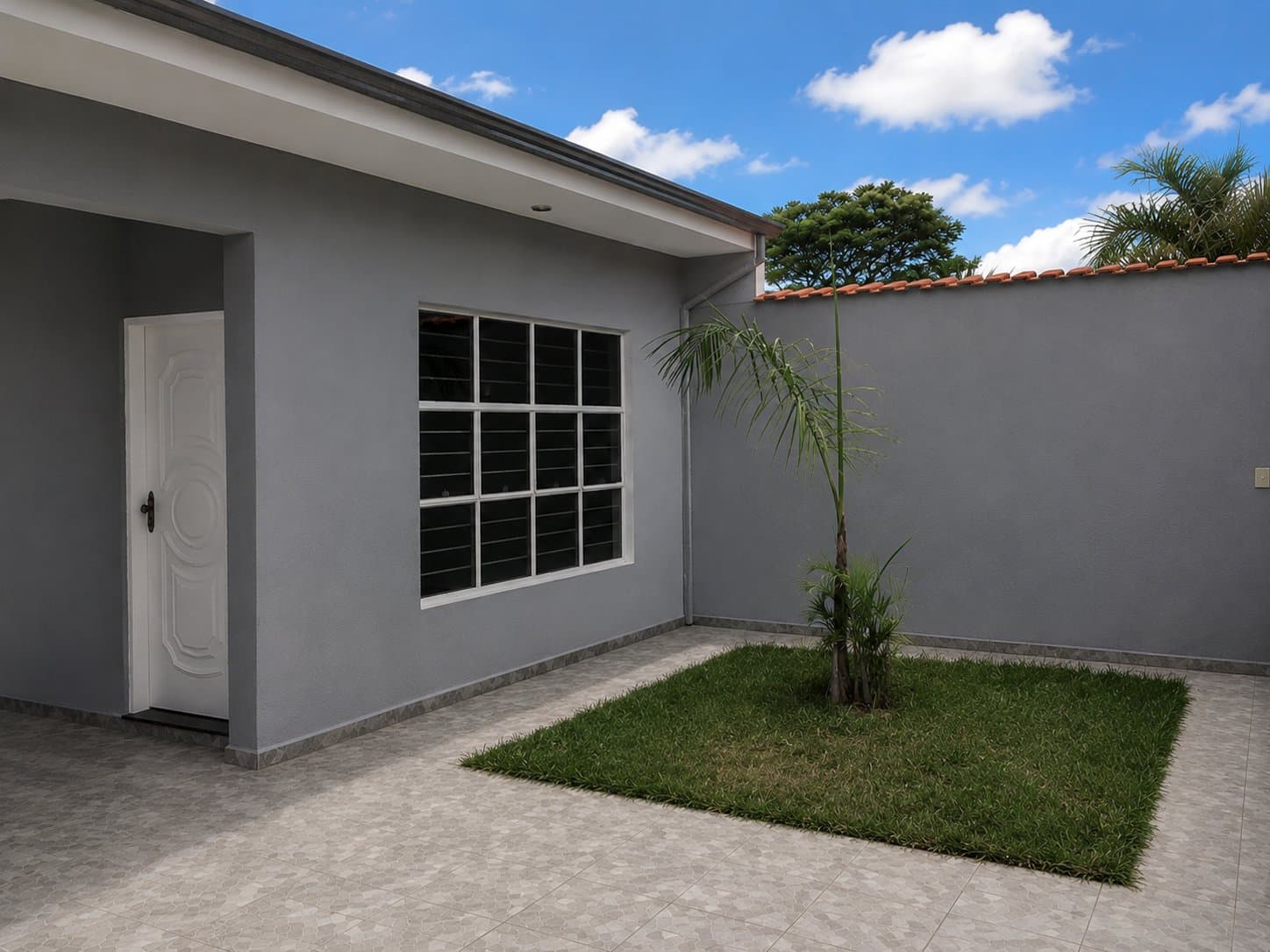 Entrada lateral da casa, com jardim e porta de acesso